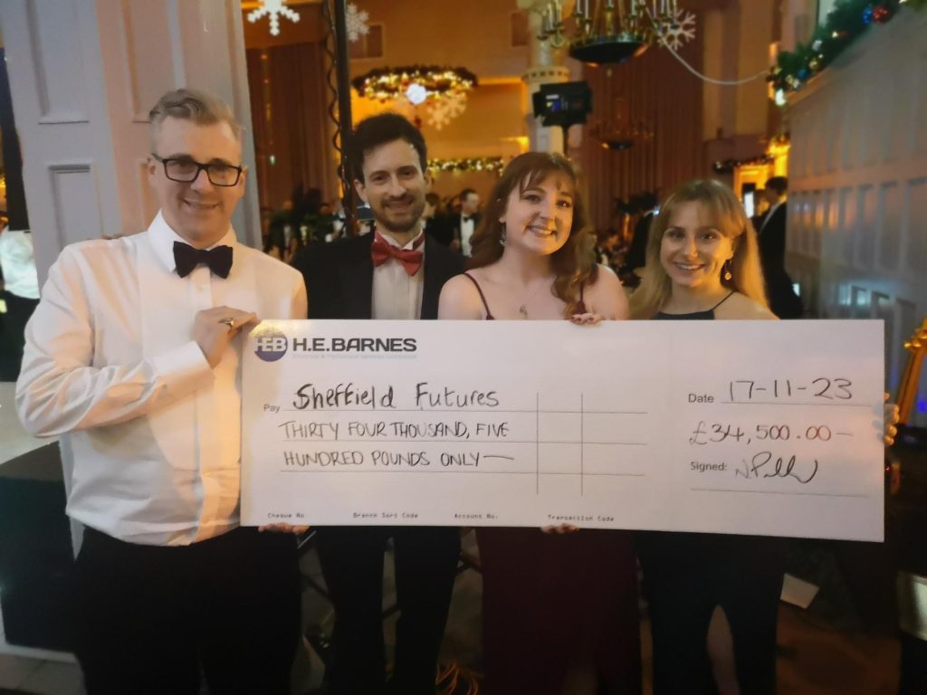 Holding the cheque, from L-R is Matt, Roo, Kate and Kirsty