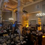 a photograph of the decorated ballroom with tables full of Gatsby-themed centrepieces